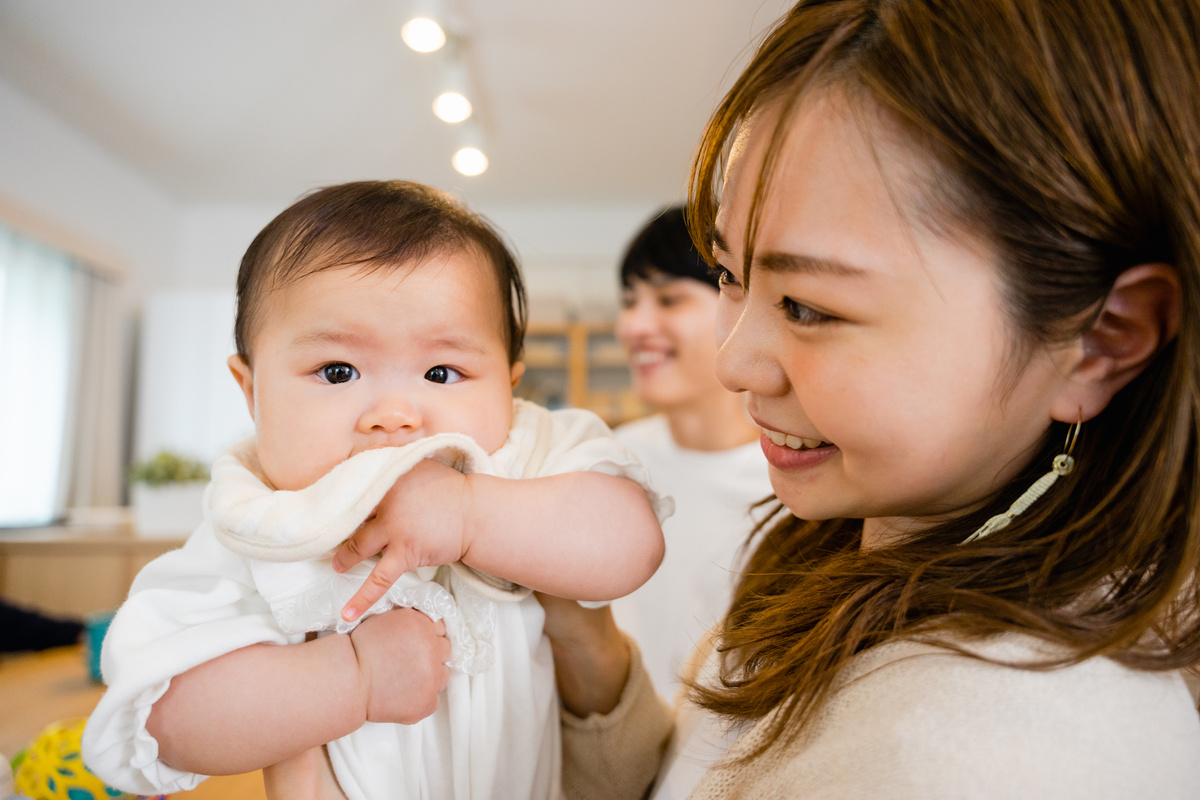 Baby, mother and father looking at the camera to be hugged